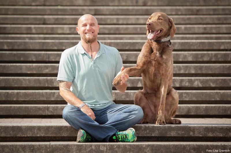Holger Schüler mit seinem Hund auf einer Treppe